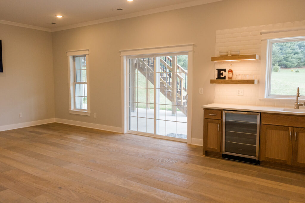 Basement finished by Van Cleave Construction, Remodeling, and Design with a bar, floating shelves with LED lighting, and lots of room for entertaining.